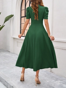 Back view of an elegant dark green knit midi dress with puff sleeves and A-line skirt