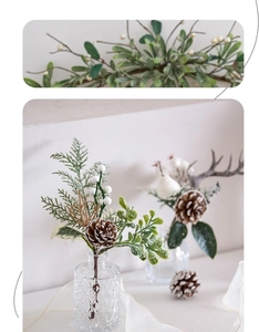 Close-up of artificial pine cones, white berries, and eucalyptus branches in a glass vase