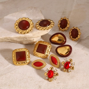 Retro stainless steel red agate earring set with zircon accents on stone background
