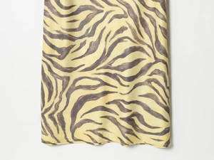 Close-up of elegant yellow zebra print fabric with a smooth and silky texture