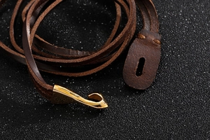 Macro di bracciale in pelle intrecciata marrone con chiusura a gancio dorata lucida