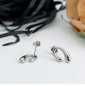 Detailed view of silver horseshoe U-shaped earrings with minimalist polished finish