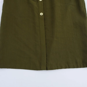 Detailed close-up of olive green midi dress featuring beige buttons and neat stitching