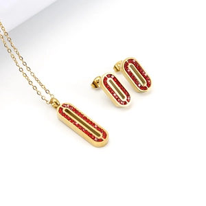 Gros plan sur l'ensemble collier et boucles d'oreilles ovales dorés à strass rouges