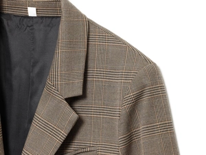 Détail du revers du blazer à carreaux marron et couture d'épaule avec doublure noire