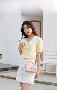 Quilted pink jelly bag with golden chain strap worn with a yellow puff sleeve top