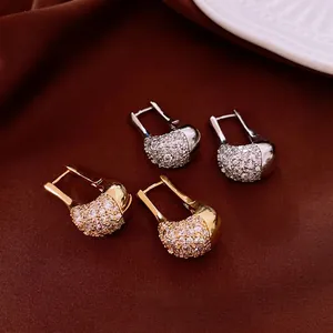 U-shaped zircon earrings set in gold and silver finish on elegant silk background