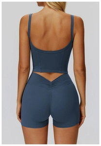 Dettaglio del set yoga blu scuro con pantaloncini a V e top sportivo con schiena scoperta