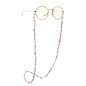 Detailed close-up of a colorful beaded eyewear chain on gold round frames over white background