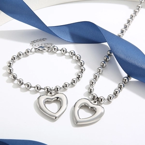 Detailed view of silver heart pendant jewelry set with beads chain on blue ribbon