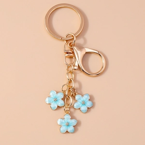 Detailed close-up of blue and gold cherry blossom flower pendants on a metal keychain