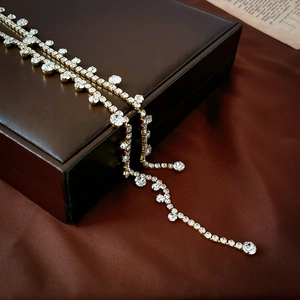 Close-up of sparkling rhinestone tassel chain draped over a brown leather jewelry box