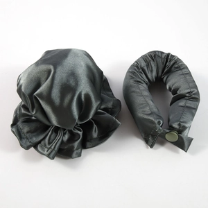 Detail of dark gray satin sleep cap and U-shaped neck pillow with button closure