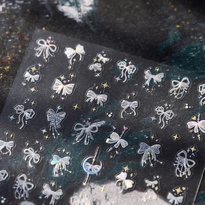 Autocollants ongles nœuds irisés avec effet holographique et étoiles sur fond noir