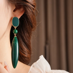 Close-up of vintage malachite drop earrings with emerald green accents and gold plating