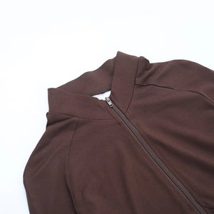 Close-up of the front metal zipper and high neck detail on the brown long sleeve jumpsuit