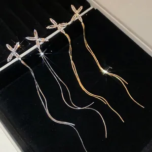 Boucles d'oreilles élégantes à pompons en zircon, coloris or et argent sur velours noir