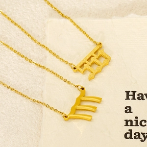 Macro view of gold 222 number and Scorpio zodiac pendants on stainless steel chains
