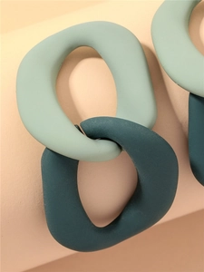 Macro view of mint green and teal matte resin chain link earrings with geometric design