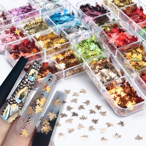 Macro shot of laser maple leaf nail sequins in a 6-grid box for autumn nail art