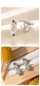 Macro detail of floral screw-back earring with pink center and blue zircon accents
