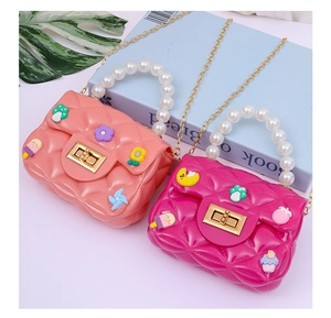 Detail of pink jelly crossbody bags with quilted pattern, pearl handles and cartoon charms