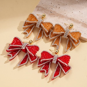 Bowtie tassel earrings with rhinestones and resin texture in red and amber orange colors