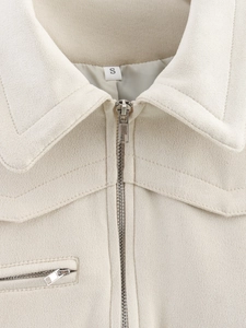 Close-up of beige faux suede jacket collar with silver zipper and size S label