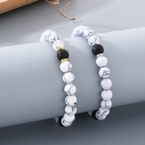 Close-up of handmade 8mm natural stone bracelets with white marble and black lava beads