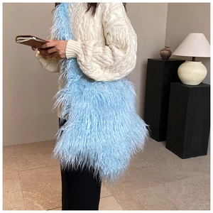 Blue plush crossbody bag with long faux fur texture styled on a beige knit sweater