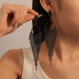 Macro detail of elegant black rhinestone fringe earrings on model with high gloss finish