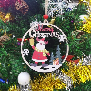 Close-up of wooden Merry Christmas hanging ornament featuring Santa Claus and pine trees