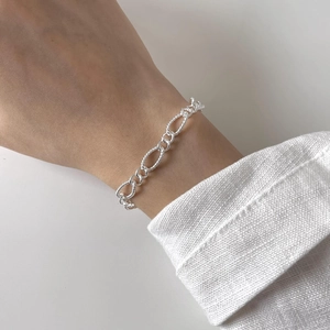 Close-up of minimalist 925 silver bracelet featuring twisted rope rings and smooth links
