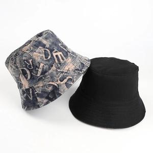 Detail of a matte suede bucket hat featuring retro letter print and a reversible design