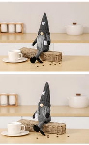 Detail of grey knitted heart gnome holding a coffee cup for Christmas decoration