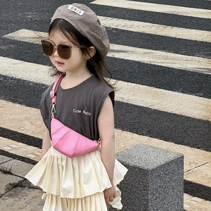 Pink horn-shaped crossbody bag for kids paired with casual outfit on street background
