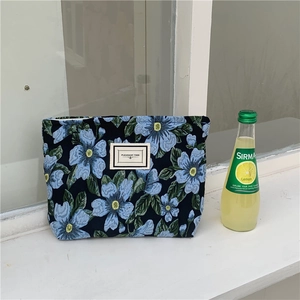 Macro detail of blue floral jacquard fabric with Pleasant Time woven label on handbag