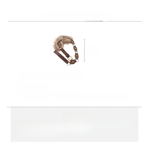 Détail d'une chaîne de taille vintage en cuir avec disques en cuivre et fausse fourrure