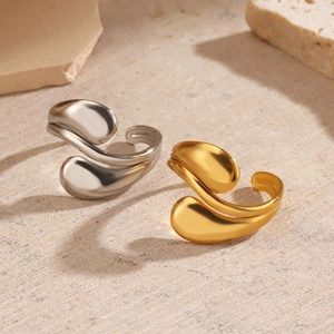 Minimalist 18K gold and silver teardrop open rings on natural stone background