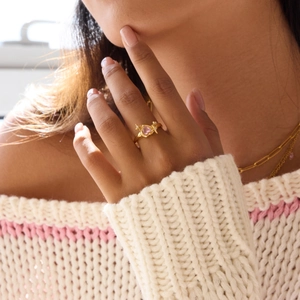 Elegant gold ring with pink heart zircon and star detail worn on index finger