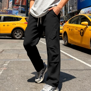 Dettaglio dei pantaloni streetwear neri larghi con tasche laterali e coulisse in vita