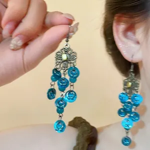 Detail view of vintage bronze flower earrings with blue translucent cascading tassels