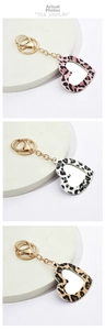 Close-up of heart-shaped leopard print mirror keychains in pink, brown and white colors