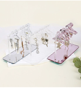 Acrylic earring stands in clear, white, and pink finishes with mini hangers for jewelry