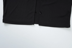 Detailaufnahme von geripptem Saum und Knopfverschluss an schwarzem Langarm-Top
