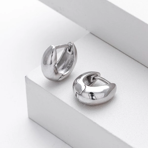 Close-up of polished S925 sterling silver hoop earrings with 925 hallmarks on white stand