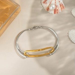 Zweifarbiger geometrischer 18K vergoldeter Armreif vor elegantem ästhetischem Hintergrund