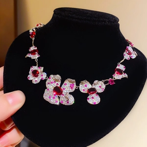 Collier floral exquis avec pierres rouges et détails en zircon blanc sur support en velours