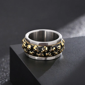 Detailed view of rotating double row skull ring in punk silver and gold titanium steel