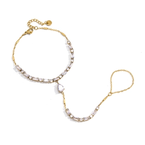 Elegant gold stainless steel finger bracelet with zircon crystals on a white background